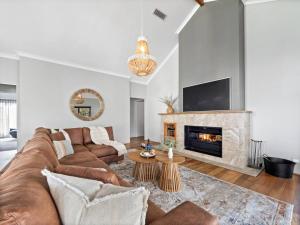 un soggiorno con divano e camino di Bickley's Place - A Luxury Retreat on the Golf Green a Dunsborough
