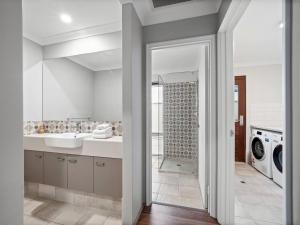 un bagno con lavandino e lavatrice di Bickley's Place - A Luxury Retreat on the Golf Green a Dunsborough Altre 27 foto
