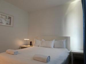 a bedroom with a bed with white sheets and pillows at Peles Green Apartment&Piano in Cluj-Napoca