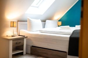 a bedroom with a bed with white pillows and a table at Ferienhaus-Nationalparkidylle in Rechlin +28 photos