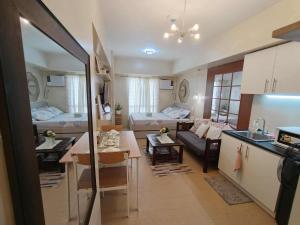 a kitchen and a living room with a couch and a table at Avida Tower 3 L21 staycation rm 117 in Iloilo City