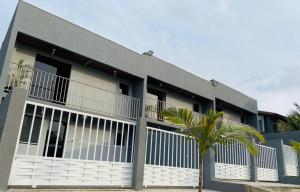 a building with a palm tree in front of it at Dk residêncial CASA INTEIRA in Pontal do Paraná