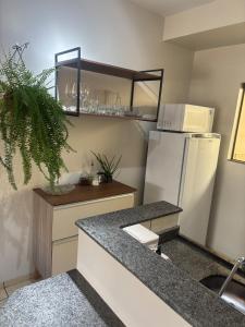 a kitchen with a white refrigerator and a counter at Zen apartment complete and garage in Tangara da Serra +13 photos
