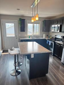 a kitchen with blue cabinets and a large island in the middle at The Urban Hideout in St. John's