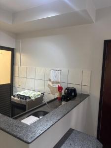 a kitchen with a sink and a phone on a counter at Zen apartment complete and garage in Tangara da Serra