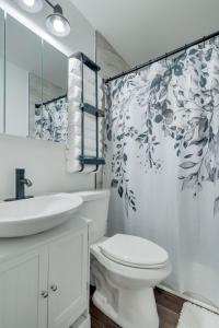 a bathroom with a toilet and a sink and a shower curtain at FSU Seminole SpearIt House in Tallahassee