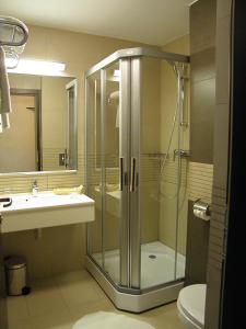 a bathroom with a shower, sink, and toilet at Hotel Berthelot in Bucharest