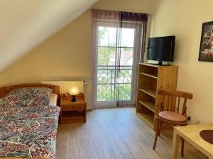 a bedroom with a bed and a tv and a table at Holiday Park Lenzer Höh VI in Lenz