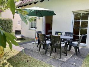 a table and chairs with an umbrella on a patio at in the Lenzer Höh I holiday park in Lenz