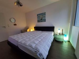 a bedroom with a large white bed and a table at Holiday apartment with 2 bedrooms in Sassnitz