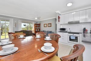 una cucina e una sala da pranzo con tavolo e sedie in legno di Windella Cottage a North Rothbury