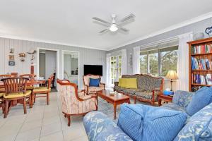 un soggiorno con divani blu e una sala da pranzo di Windella Cottage a North Rothbury