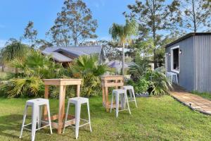un gruppo di tavoli e sgabelli in un cortile di Windella Cottage a North Rothbury