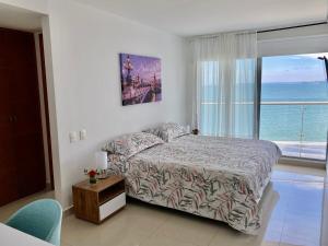 a bedroom with a bed with a view of the ocean at Ikigai frente al mar con piscina infinita y Gym in Cartagena de Indias +70 photos
