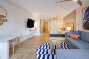 a living room with a couch and a bed at The Sebel Palm Cove in Palm Cove