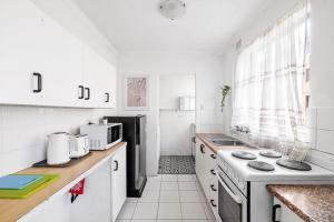 a kitchen with white cabinets and a black refrigerator at Modern Private Single Room - Centrally Located at Liverpool - Shared Bathroom in Liverpool
