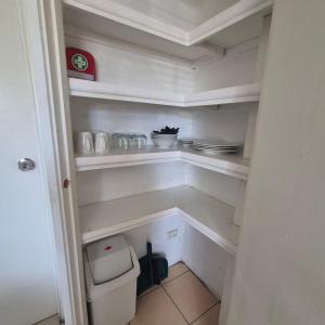 a small white pantry with a toilet in it at Breezy Retreats A Cosy Getaway in Kingston