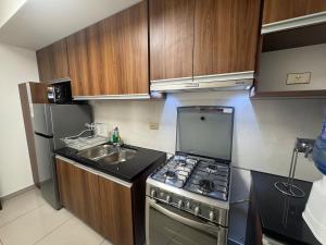 une petite cuisine avec une cuisinière et un évier dans l'établissement Beautiful Family Apartment with Pool WiFi Central Team, à Santa Cruz de la Sierra