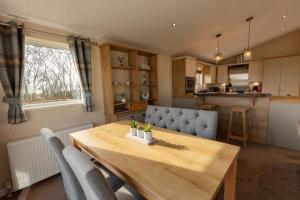 a kitchen and dining room with a wooden table and chairs at The Suncatcher in Swarland +15 photos