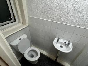 a bathroom with a toilet and a sink at Reads Avenue 1 Bed Apartment - Next To H&A Social Club - Minutes from Winter Gardens & Town Centre! in Blackpool +6 photos