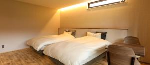 two beds in a small room with aermottermottermottermott at Hotel 4CROWNS-GRAND ゴールドプラン in Katsuyama