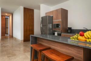 a kitchen with a counter with a plate of fruit on it at Relaxing 2BR Condo Omara with Direct Pool Access in Tulum