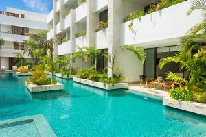 a swimming pool in the middle of a building at Relaxing 2BR Condo Omara with Direct Pool Access in Tulum