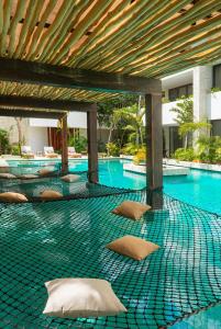 a swimming pool with pillows on the ground at Relaxing 2BR Condo Omara with Direct Pool Access in Tulum