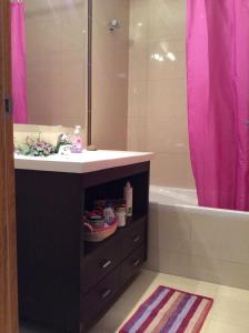 baño con lavabo y cortina de ducha rosa en Patacão&Violeta, en Faro