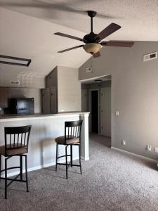 an empty living room with two chairs and a ceiling fan at Modern & Cozy Apartment Stay in Olathe
