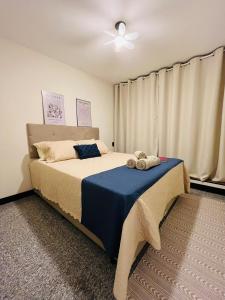 a bedroom with a bed with a blue blanket at Studio Aconchego - 2 Bedrooms with Wi-Fi Subway in Sao Paulo +59 photos