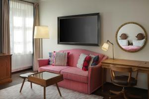 a living room with a pink couch and a mirror at Hotel Goldener Hirsch, A Luxury Collection Hotel, Salzburg in Salzburg