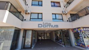a building with a sign that reads entry to domus at Aire de Mar Alojamiento Necochea in Necochea