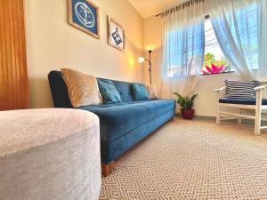 リオ・ダス・オストラスにあるCasa Maresia BLU - próximo à praia de Costa Azulの青いソファと窓のあるリビングルーム