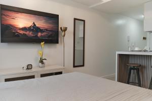 a bedroom with a white bed and a tv on the wall at M&R Condotel Azure North in San Fernando +11 photos