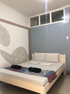 a bedroom with a bed with two black hats on it at Traveler's Home in Cebu City