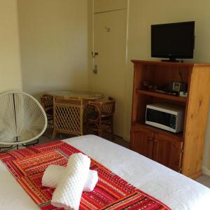 a bedroom with a bed with a television and a table at Abel Tasman Waterfront Motel in Lakes Entrance