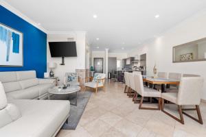 a living room with a couch and a dining room at Condo Paraiso - Luxurious new condo 300mt from the beach in Cabo San Lucas
