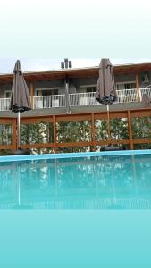 een gebouw met een zwembad met twee parasols bij Seven76Residence in Barra Velha