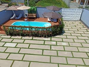 a swimming pool with umbrellas on a patio at Seven76Residence in Barra Velha