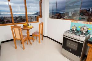 cocina con fogones y mesa con sillas en Cristallina downtown, en Puno