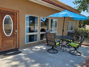 a patio with a table and chairs and an umbrella at Casita La Mesilla in Espanola