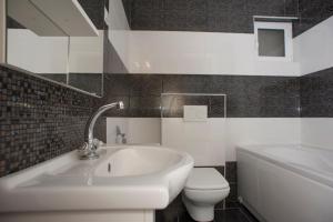 a bathroom with a sink and a toilet and a tub at Apartments Peđa in Sveti Stefan