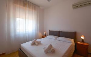 a bedroom with a white bed with two pillows on it at Beautiful Home In Marzamemi in Marzamemi