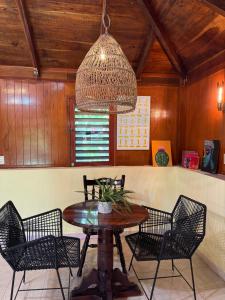 a dining room with a table and chairs and a chandelier at Maïa Bacalar in Bacalar