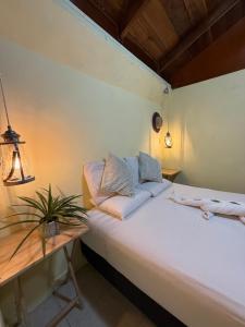a bedroom with a white bed and a table at Maïa Bacalar in Bacalar