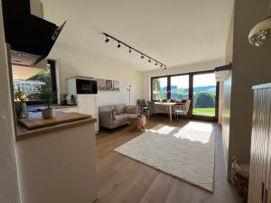 a living room with a kitchen and a living room with a table at Neu - Ferienwohnung Allgäuparadies - Traumhafte Aussichten mitten in der Natur des Westallgäus in Oberreute