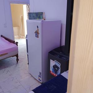 a white refrigerator and a television in a room at Roof Top Studio Apartment in New cairo