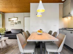 a kitchen and dining room with a table and chairs at Bungalow in Putten near Veluwe Forest in Putten