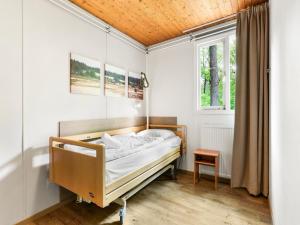 a bedroom with a bed and a window at Bungalow in Putten near Veluwe Forest in Putten +18 photos